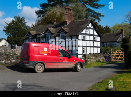 Un Royal Mail post van al di fuori di un bianco e nero cottage in Eardisland, Herefordshire, Inghilterra. Foto Stock