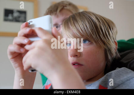 Ragazzi giochi su un iPod a casa Foto Stock