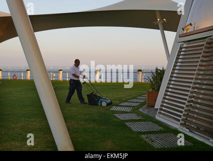 Un uomo di falciare un prato sul ponte della nave da crociera Celebrity Equinox. Foto Stock