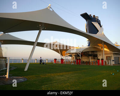 Un uomo di falciare un prato sul ponte della nave da crociera Celebrity Equinox. Foto Stock