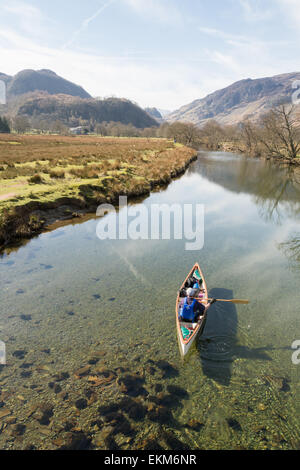Uomo e cane visto dal Ponte cinese paddling in canoa lungo il fiume Derwent vicino a Derwentwater nel Lake District inglese Foto Stock