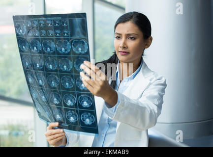 Closeup ritratto di donna intellettuale personale sanitario con il bianco labcoat, guardando a corpo pieno di raggi x immagine radiografica Foto Stock