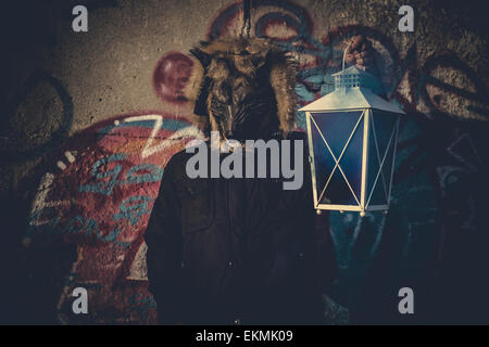 Scary, l uomo con maschera Wolf e lampada con fumo colorato Foto Stock