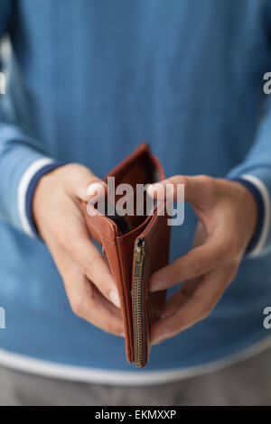 Aprire il portamonete marrone in mani maschio Foto Stock