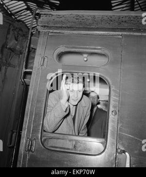 British pop singer Terry Dene sventolare dal treno finestra carrello come egli lascia per Winchester Caserma dove egli inizia i suoi due anni di servizio nell'esercito. Il 24 gennaio 1959. Foto Stock