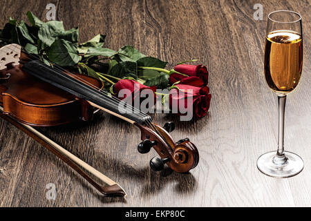 Violino, rose, bicchiere di champagne e libri di musica Foto Stock