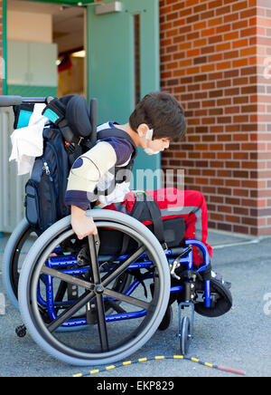 Kindergartener disabili in sedia a rotelle sul parco giochi in corrispondenza del recesso Foto Stock