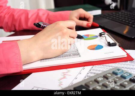 Donna controllo di bilancio o un libro paga con una calcolatrice Foto Stock