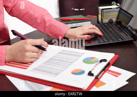 Donna controllo di bilancio o payroll con il computer portatile Foto Stock