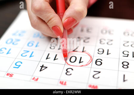 Close-up della donna evidenziando la data sul calendario Foto Stock