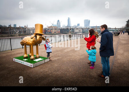 I genitori fotografare il loro bambino da uno dei Shaun nella città sculture lungo il Tamigi a Londra Foto Stock