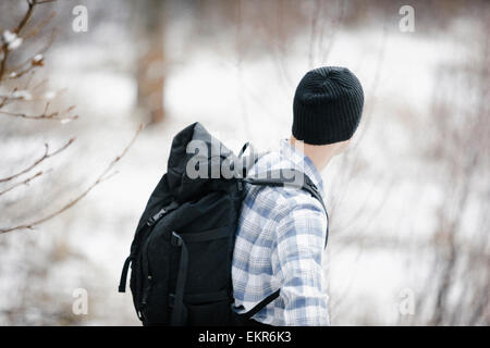 Un escursionista in montagna con uno zaino e un cappellino. Foto Stock