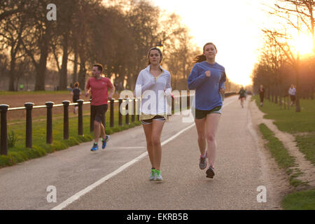 Per gli amanti del jogging godendo il sole serale in Hyde Park, London Knightsbridge, Londra, Regno Unito Foto Stock