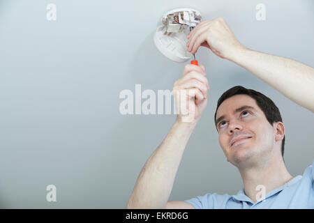L'uomo Installazione di fumo o di monossido di carbonio rilevatore Foto Stock