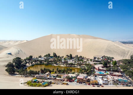 Oasi del deserto di Huacachina con una duna di sabbia sollevandosi al di sopra di esso vicino Ica, Perù Foto Stock