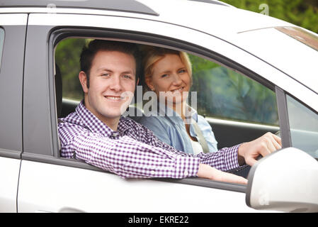 Ritratto di Coppia Giovane guardando fuori della finestra Auto Foto Stock
