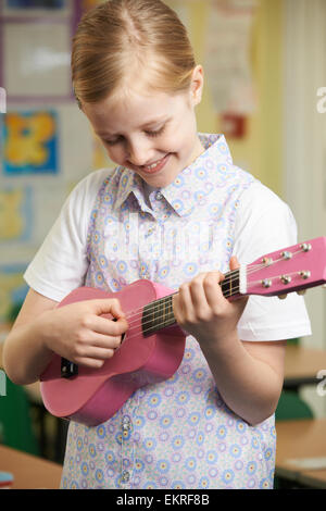 Ragazza imparare a suonare Ukulele a scuola lezione di musica Foto Stock