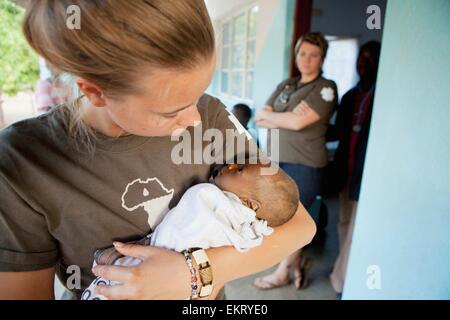 L'infermiera consolante un bambino a morire di HIV/Aids; Manica, Mozambico, Africa Foto Stock