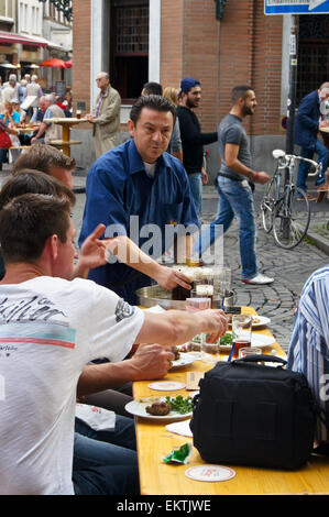 Köbes (barman) servente Altbier a Uerige brauhaus, Düsseldorf, Renania settentrionale-Vestfalia, Germania pub tavola bicchieri di bevande Foto Stock