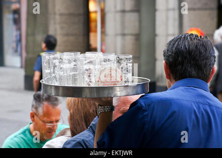 Köbes (barman) servente Altbier a Uerige brauhaus, Düsseldorf, Renania settentrionale-Vestfalia, Germania pub tavola bicchieri di bevande Foto Stock