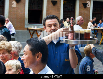 Köbes (barman) servente Altbier a Uerige brauhaus, Düsseldorf, Renania settentrionale-Vestfalia, Germania pub tavola bicchieri di bevande Foto Stock