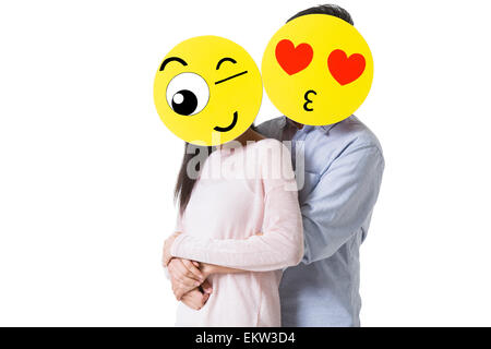 Coppia giovane con il cartoon emoticon volti nella parte anteriore delle loro facce Foto Stock