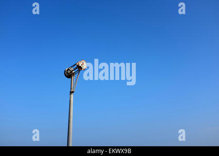 Resti di una turbina eolica danneggiati da venti costieri e meteo contro un cielo blu Foto Stock