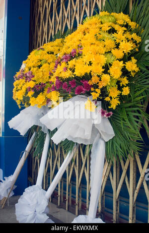 Ghirlande di fiori utilizzati per il Khmer NewYear offerte buddista resto in vendita su una strada di città in Kampong Cham, Cambogia. Foto Stock