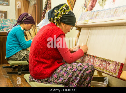 Le donne turche tradizionali di tessitura a mano di tappeti, nei pressi di Antalya, regione mediterranea, Turchia Foto Stock