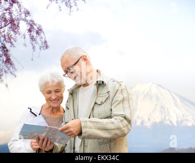 Felice coppia senior con mappa di viaggio sulle montagne Foto Stock