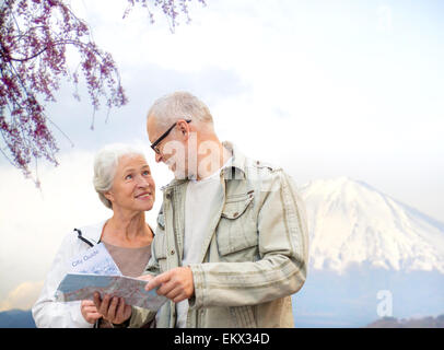 Felice coppia senior con mappa di viaggio sulle montagne Foto Stock