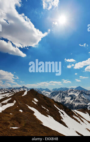 Il sole e il blu cielo nuvoloso sopra la molla tatry montagne, con resti di neve Foto Stock
