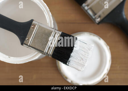 Pittura e decorazione shallow focus vista dall'alto in basso di un vaso di vernice bianca e pennello Foto Stock