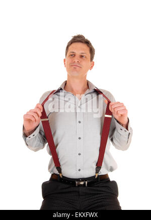 Un sorridenti giovane uomo in grigio di una camicia con red suspender seduta isolato per sfondo bianco. Foto Stock