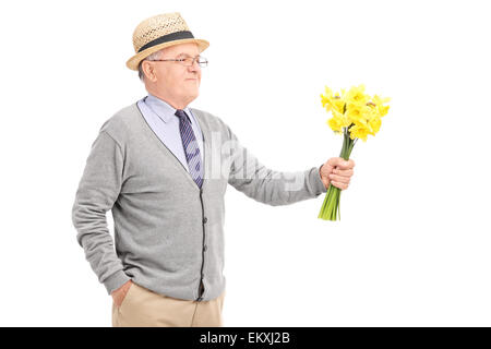 Allegro senior gentleman tenendo un mazzo di tulipani gialli isolati su sfondo bianco Foto Stock