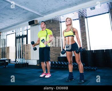 Donna e uomo che lavora fuori con manubri in palestra Foto Stock