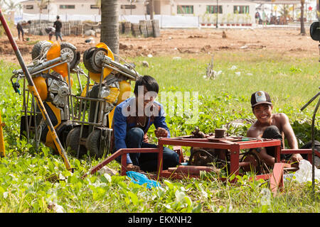 I giovani lavoratori di divertimenti di assemblaggio giostra per il Kep Sea festival in Cambogia. Foto Stock