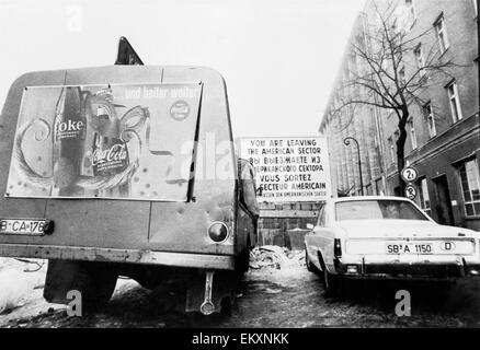 Una Coca Cola camion sulla linea del fronte della libertà in un vento spazzato Rainy day a Checkpot Charlie su berlinese di Friedrich Strasse. 9 gennaio 1970 Foto Stock