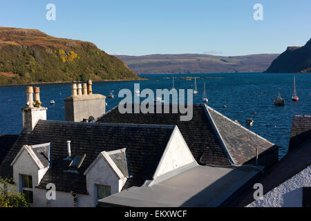 Guardando oltre il case tradizionali in Portree per barche da pesca sul porto. Foto Stock