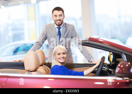 Coppia felice l'acquisto di auto in auto show o salon Foto Stock