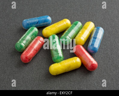 Un gruppo di capsule colorate su uno sfondo nero. Foto Stock