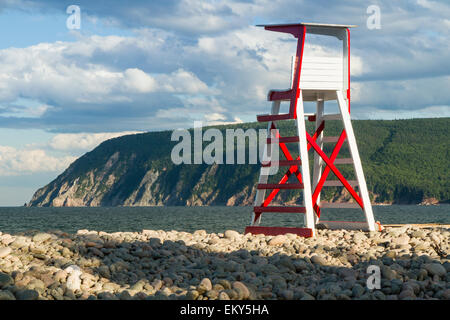 Un bagnino sedia sui rocciosi Ingonish Beach, con Capo Smokey in background in Cape Breton Highlands, Nova Scotia Foto Stock