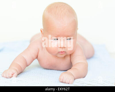 Carino baby posa sull'asciugamano blu Foto Stock