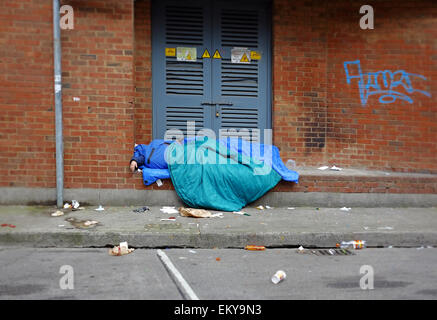 Verso il basso e fuori senzatetto sonno agitato in entrata di un locale nella città di Dublino Foto Stock