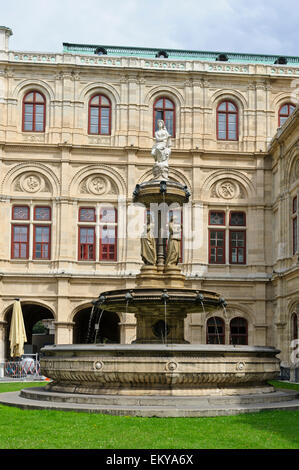 Una fontana di acqua con sculture al di fuori dello Stato Teatro dell'Opera, Vienna, Austria. Foto Stock