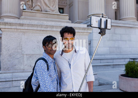 Due amici maschi di scattare una foto con la bacchetta selfie - USA Foto Stock