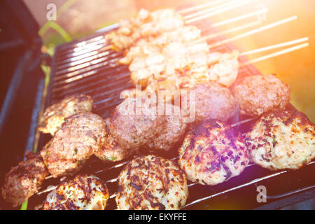 Gli hamburger e carne satays grigliare sul barbecue pronto per l'estate cene all'aperto Foto Stock