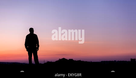 Silhouette di uomo e bellissimo cielo. Elemento di design. Tramonto d'estate. Sfondo Foto Stock