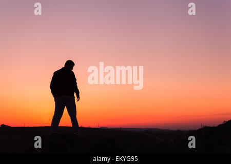 Silhouette di uomo e bellissimo cielo. Elemento di design. Tramonto d'estate. Sfondo Foto Stock