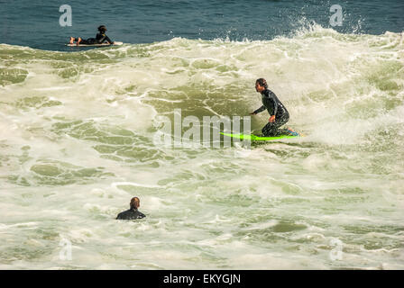 Surfista Kneeboarding germogli attraverso una grande, overhead shorebreak wave a Malibu Beach, California. Stati Uniti d'America. Foto Stock